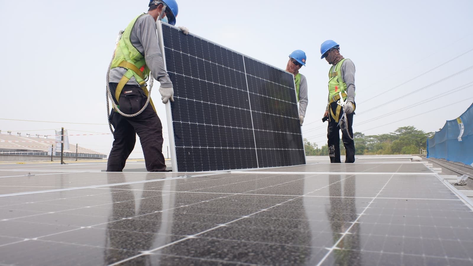 Equipe técnica instalando painéis solares em telhado residencial